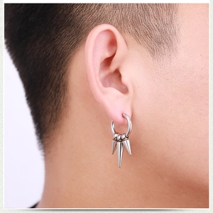 Close-up of stainless steel hoop earring with three conical spikes on a male model's ear