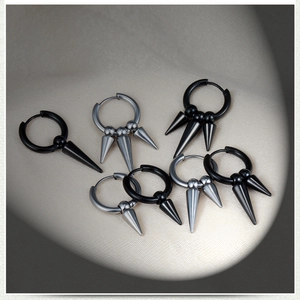Close-up of stainless steel hoop earrings with punk cone charms in black and silver