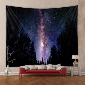 Deep space galaxy wall tapestry with dark pine forest silhouettes over a red modern sofa