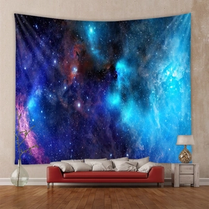 Cosmic galaxy tapestry with purple nebula hanging above a red sofa in a cozy room