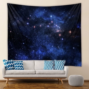 Detailed view of dark blue starry sky tapestry hanging above a modern white sofa