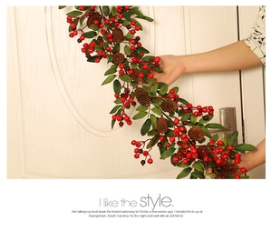 Close-up of Christmas decorative wreath with red berries and pine cones on a door