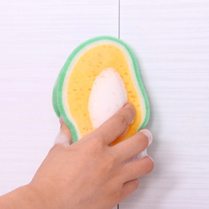 Avocado-shaped thick cleaning sponge being squeezed to show high foam and flexibility