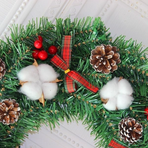 Classic Christmas wreath with red berries, pine cones and a green plaid ribbon bow