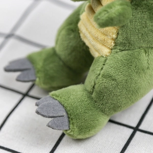 Macro view of plush dinosaur feet with grey felt claws and green velvet texture