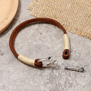 Handmade brown leather cord bracelet with vintage silver horseshoe clasp on stone texture
