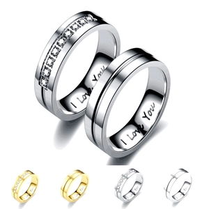 Macro detail of 'I Love You' engraving and crystals on stainless steel couple rings