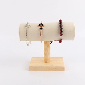 Close-up of T-bar jewelry stand with natural wood base and beige velvet bracelet holder
