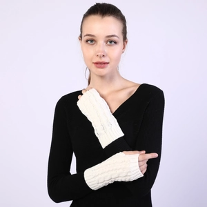 Detail of cream cable knit fingerless gloves showing warm textured crochet patterns
