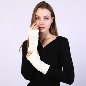 Close-up of cream white cable knit fingerless arm warmers showing soft wool texture