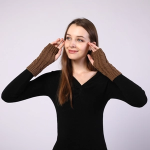 Detailed cable knit texture of dark brown fingerless arm warmers on model's hand