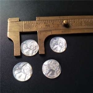 Macro detail of round natural shell angel cameo pendants with precise measurement scale