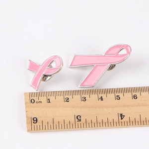 Pink ribbon pins set in two sizes on white background with scale for breast cancer awareness