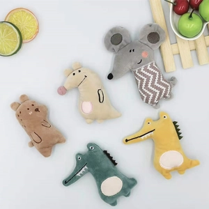 Macro detail of cartoon plush animal brooches featuring mouse, bear and crocodile dolls