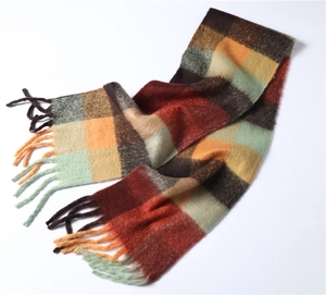 Gros plan d'une écharpe à carreaux multicolores avec des franges douces et une texture laine