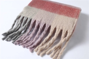 Gros plan d'une écharpe à rayures roses et grises avec franges douces et texture maille
