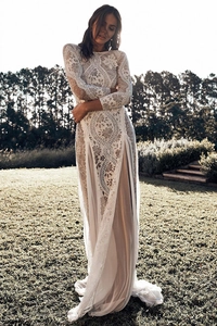 Macro detail of elegant white lace dress showing intricate floral patterns and embroidery