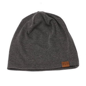 Detail of dark gray knit beanie featuring a brown leather patch with F & S embossed logo