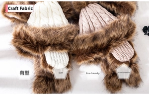 Detail of chunky knit winter hat with thick faux fur trim and cozy pompom earflaps