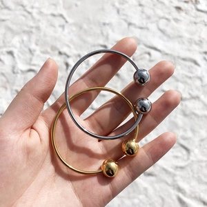 Detail of elegant gold and silver open ball bracelets worn on wrist with metallic finish