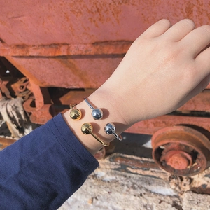 Detailed view of dual metal spheres on minimalist adjustable open cuff bracelets