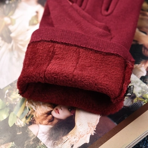 Deep red thickened warm gloves with plush lining and ribbed cuffs on fashion magazine