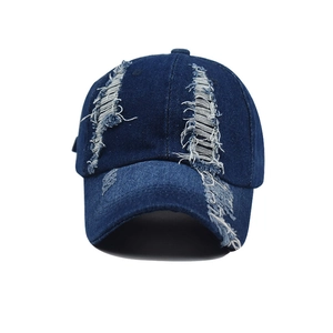 Detail of distressed navy denim baseball cap showing vintage frayed edges and texture