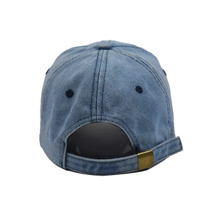 Detail of adjustable brass buckle and strap on washed blue denim baseball cap back