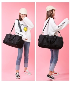 Detail of black sports travel bag showing side shoe compartment and adjustable shoulder strap