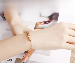 Gros plan du bracelet barrette en or rose avec zircons sur poignet avec fond de magazine