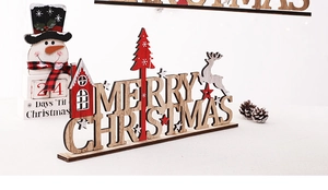 Detail of wooden Merry Christmas table sign featuring reindeer, trees and star elements