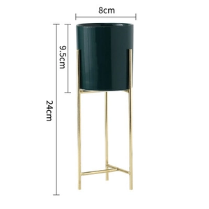 Vista dettagliata del vaso in ceramica verde scuro con il suo supporto in metallo dorato