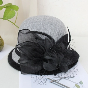 Detailed close-up of wool felt cloche hat with mesh veil and black feather floral accents