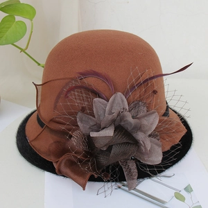 Detail of brown wool fedora with decorative satin flower, mesh net, and feathers
