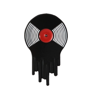 Close-up of melting vinyl record enamel pin with black drip design and red center