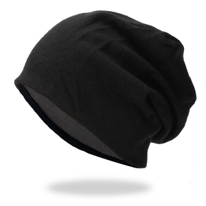 Close-up of thick knitted beanie showing soft black texture and warm grey fleece lining