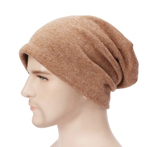 Close-up of brown knit slouchy beanie showing thick fabric texture and pleated layers