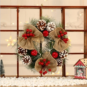 Premium Christmas wreath with pine cones and red berries on a dark wooden window