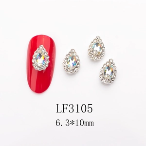 Macro shot of 6.3x10mm teardrop crystal nail charm with silver base on red manicure