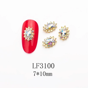 Detail of 7x10mm oval K9 glass nail jewel with alloy base on a red manicure