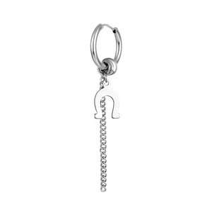 Macro detail of silver titanium steel hoop earring with horseshoe pendant and long tassel