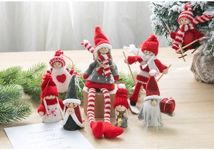 Detailed view of handmade Christmas felt angel and Santa dolls on a pine branch background