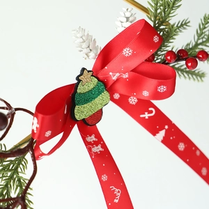 Vue macro d'un nœud de Noël rouge avec renne, sapin vert et branches de pin