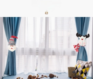 Detail of plush Santa and reindeer Christmas curtain buckles with red plaid knit hats