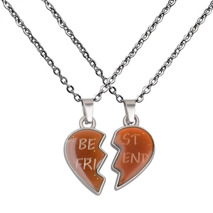Close-up of split heart Best Friend necklaces with orange gradient resin and silver chain