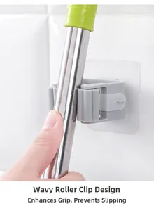 Detail of grey wall-mounted mop holder with non-slip silicone rollers on white tiles
