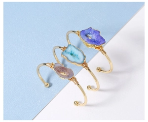 Detail of copper wire wrapped natural druzy agate stones on gold adjustable open bangles
