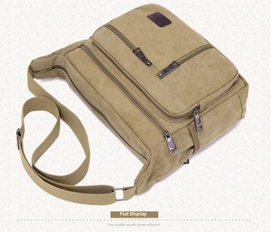 Detail view of khaki canvas crossbody bag with multiple zip pockets and adjustable strap