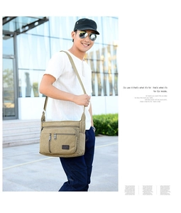 Detail of khaki canvas crossbody bag showing multiple zipper pockets for men
