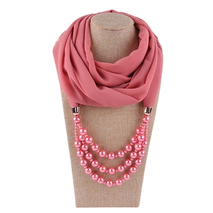 Detail eines rosa Chiffon-Schal-Halskette mit Perlen auf einer beigen Schaufensterpuppe